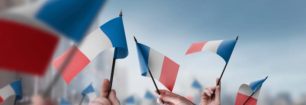 France flags in their hands on a blurred urban background. The photo illustration was created without the use of artificial intelligence, only using Photoshop.