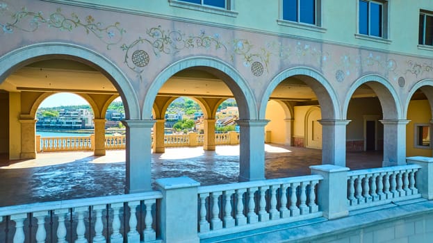 Elegant Mediterranean-style arches overlook Lake Las Vegas and modern waterfront homes, capturing luxury architecture, serene water views, and upscale living in vibrant Nevada.
