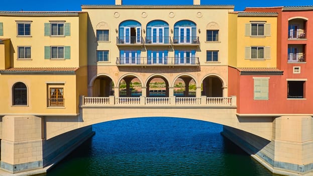 Elegant Mediterranean-style bridge connects colorful buildings over a serene canal at Lake Las Vegas in Nevada, USA, capturing luxury waterfront living and European-inspired architectural beauty.