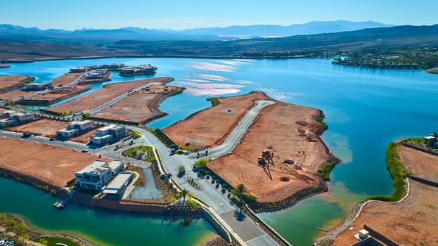 Aerial view of modern lakeside homes and construction at Lake Las Vegas Nevada with sparkling blue water desert mountains and new roads highlighting luxury real estate and urban development