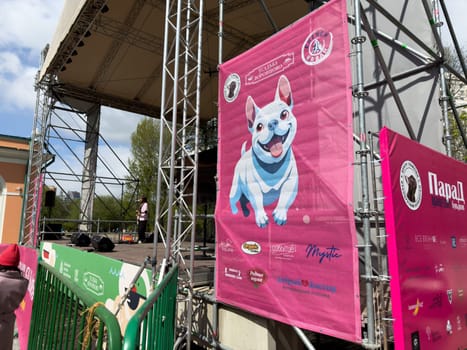 Moscow, Russia, April 27, 2025: Colorful banners with French Bulldog artwork and pet brand logos displayed near the stage at the French Bulldog Parade in Vorontsovsky Park