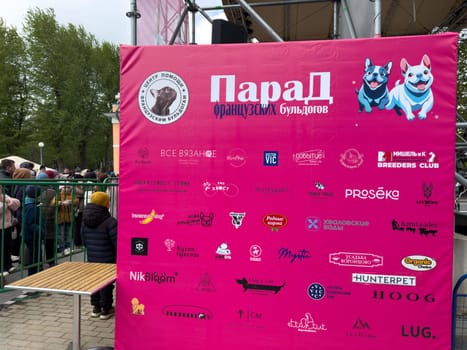 Moscow, Russia, April 27, 2025: Colorful sponsor banner displays logos of pet brands and businesses supporting the French Bulldog Parade in Vorontsovsky Park