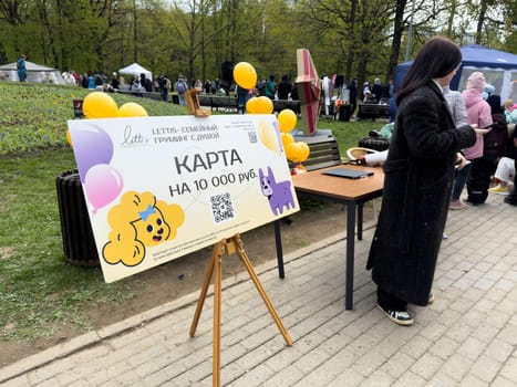 Moscow, Russia, April 27, 2025: Promotional stand by Lettis grooming studio offers a 10,000 ruble gift card during the French Bulldog Parade in Vorontsovsky Park