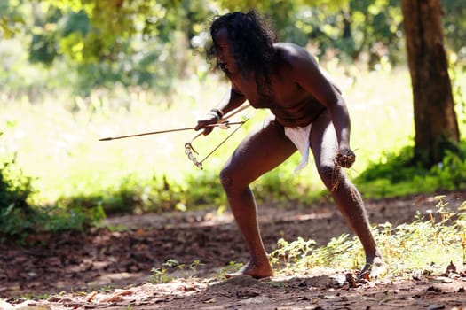 Vedda tribesman of Sri Lanka Hunting in the jungle with a bow and arrow, traditional lifestyle, and connection to nature. Tribal portrait in native Habitat. 02.03.2022 SRI LANKA.