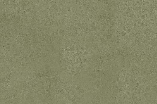 Old, worn green plaster on the wall close-up. Brownish green wall surface.