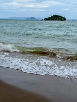 Exotic scenery of amazing small islands capturing the beauty of Thailand, coastline where waves meet soft sand under a bright summer sky. Tropical stunning sandy lagoon beach.
