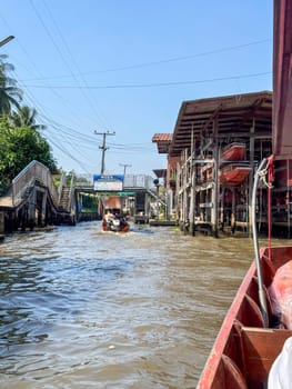 Bangkok, Thailand - November 12, 2024: Colorful floating market with boats selling food, local bazaar where vendors sell Thai seafood or traditional produce. Authentic cultural experience.