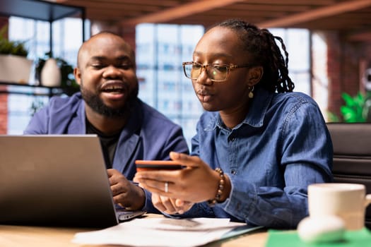 Responsible man and woman paying bills and doing their taxes on the laptop, entering payment details on web and confirming the money transfer. Online banking and managing finances at home.