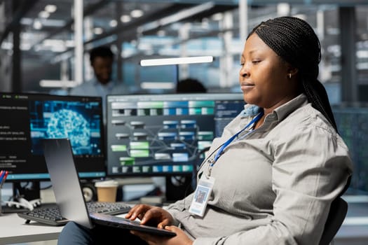 Data center admin using artificial intelligence neural networks node trees on laptop. Server room specialist using using AI programming language on notebook, configuring specialized hardware