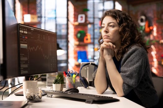 Financial investor works on PC analyzing stock market trends. The digital interface displays price fluctuations, candlestick charts. Liquidity statistics helps strategize future trading decisions.
