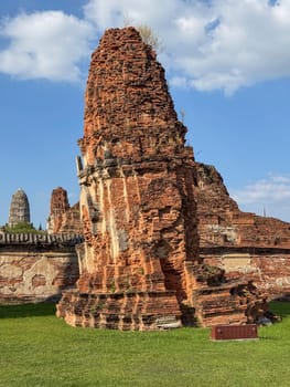 Breathtaking view of Wat Maha That Buddhist temple building in the sunlight, admiring ancient brick architecture at the famous Thailand landmark. Spiritual and cultural tourist attraction.