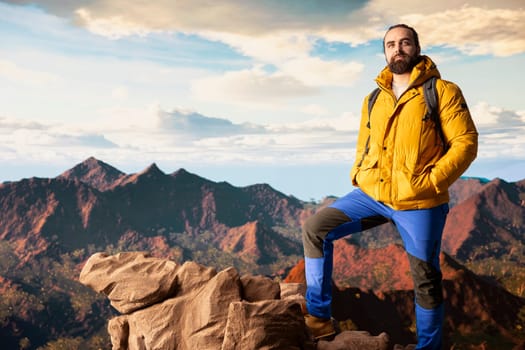 Hiker gazes at the panoramic view of dramatic mountain peaks and clouds, feeling the thrill of adventure and rewards of perseverance. The journey represents strength and personal growth.