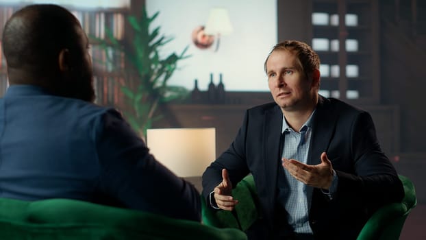Two diverse gentlemen in a private classy social club discussing career advancement and money making while they are enjoying a sophisticated whiskey experience. Upper class society. Camera B.