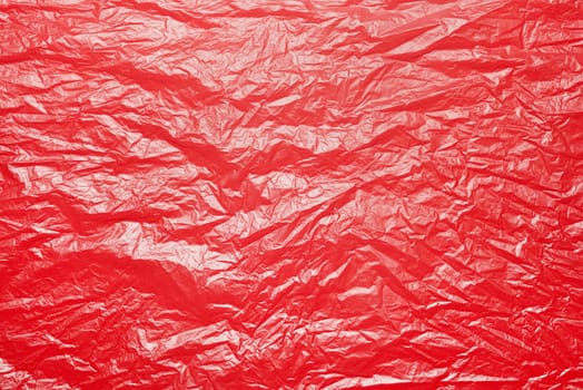 A textured red crumpled paper background with natural creases and folds. Ideal for design projects, digital graphics, or creative presentations requiring a vibrant
