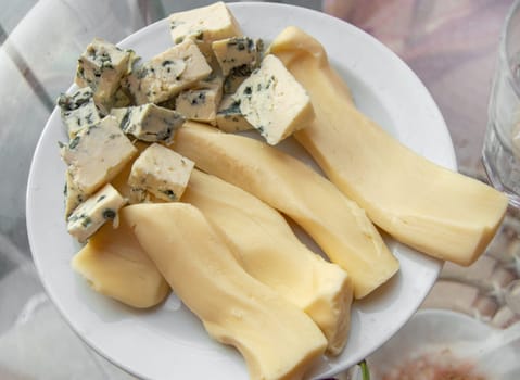 Blue cheese with noble mold, diced, on a plate, top view.