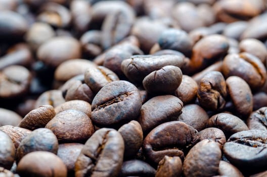 Close up view roasted coffee beans that highlights the texture and surface details of the coffee beans with customizable space for text.