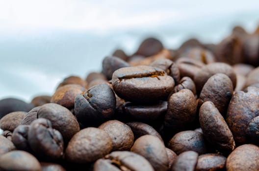 Side view of roasted coffee beans on white background with customizable space for text.