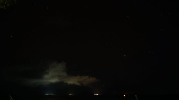 Illuminated clouds drifting gracefully beneath a breathtaking starry night sky create a captivating celestial scene, inviting awe and wonder in the tranquil atmosphere of the cosmos