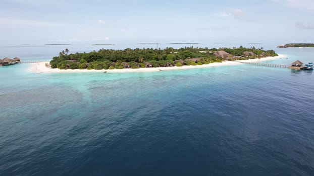 Idyllic island resort in the maldives featuring luxurious bungalows surrounded by lush vegetation, pristine white sand beaches, and a captivating turquoise lagoon