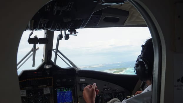 Airplane pilot navigating through the skies above a tropical maldives island, preparing for landing with a stunning turquoise lagoon and ocean in the captivating background