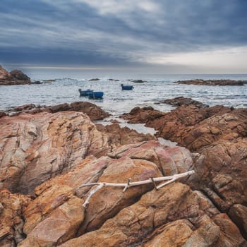 Seascape with Vietnamese round basket boats floating in sea next to rocks