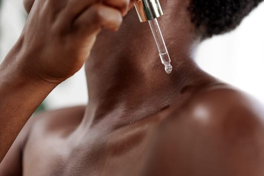 A person applies a dropper serum to their neck, focusing on skin health and hydration. The setting is a well-lit room, emphasizing self-care and beauty routine.