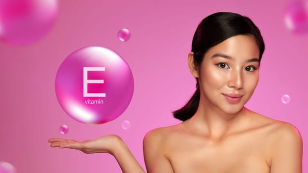 A model poses with a playful expression, holding a large bubble indicating Vitamin E, surrounded by floating bubbles on a pink backdrop that enhances the beauty theme.