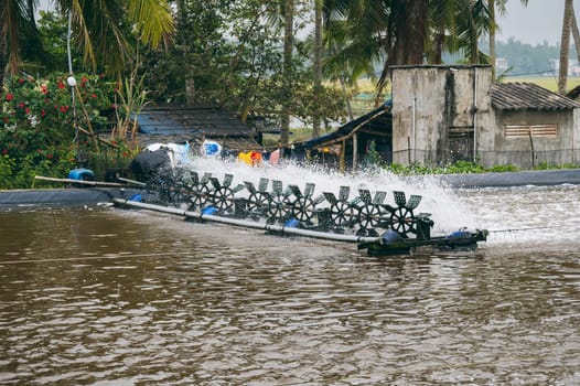 Aerator blades in pond on fish farm. Breeding fish and shrimps in an artificial pond