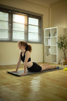 Female athlete stretching on a yoga mat. Home workout concept.