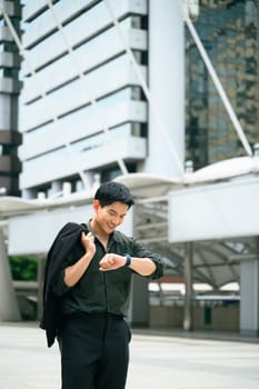Modern businessman checking the time on his smartwatch in a city business district.