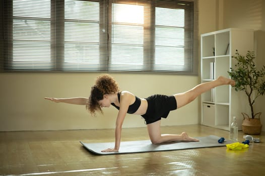 Female athlete stretching on a yoga mat. Home workout concept.