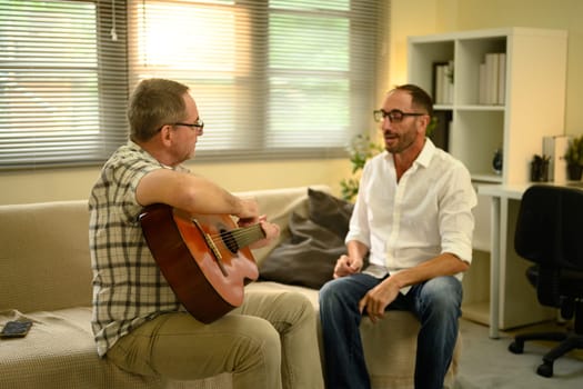 Family connection and joy expressed through a guitar session in a cozy room. Fathers day concept.