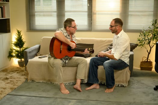 Family connection and joy expressed through a guitar session in a cozy room. Fathers day concept.