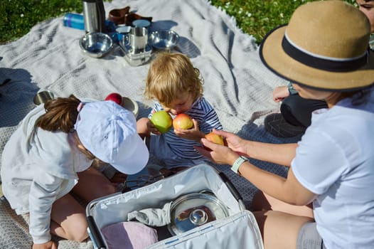 Family enjoying quality time outdoors during a sunny day, sharing food and moments together. Celebrating family connections and the joy of eating outside during pleasant weather.