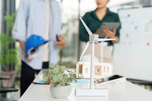 Two colleagues collaborate on sustainable energy projects, emphasizing ESG principles in a bright workspace.