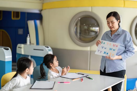 A teacher utilizes visual aids to engage students in a lively classroom, promoting effective learning strategies.