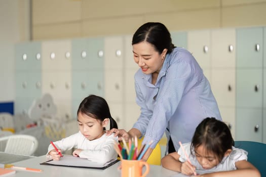 A teacher supports children during a creative activity in a lively classroom, emphasizing engagement and collaboration.