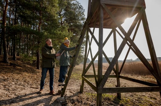 Dad And Daughter Walking In The Forest Near The Lookout Tower In Spring