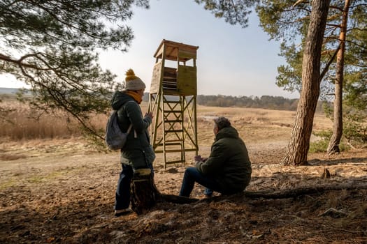 Dad And Daughter Drinking Tea From A Thermos Near The Observation Tower In Spring