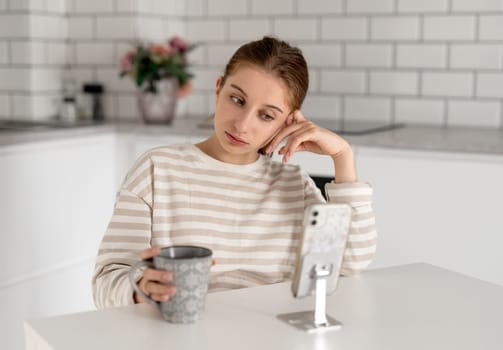 Sad Teen Girl At Home Looking At Something On Smartphone