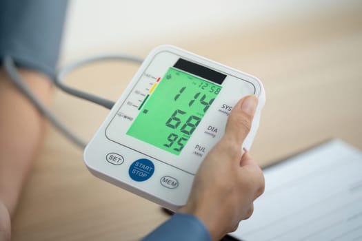 A healthcare professional displays the results of a digital blood pressure monitor, ensuring patient understanding and care.