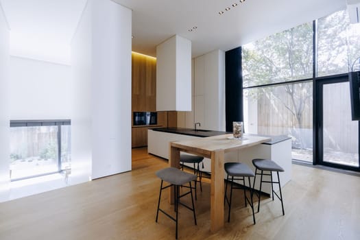 This kitchen features a sleek black countertop that contrasts beautifully with elegant white cabinets, creating a modern aesthetic