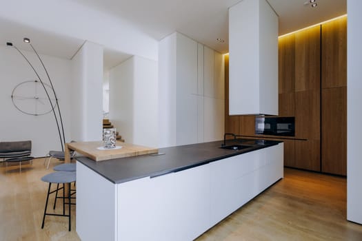 This kitchen features a sleek black countertop that contrasts beautifully with elegant white cabinets, creating a modern aesthetic