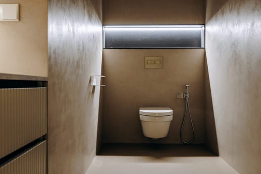 The bathroom contains a toilet and a bidet which are both attached to the wall, providing a functional space for personal hygiene needs