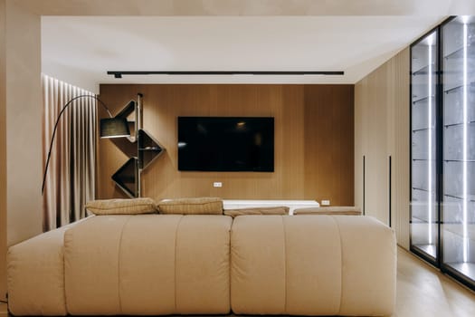 In a comfortable and inviting living room, there is a stylish couch positioned prominently, and on the wall above, a sleek flat screen television is mounted