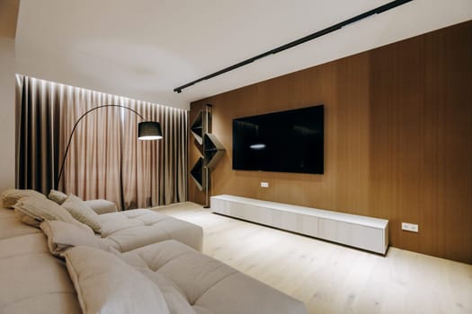 In a cozy living room, there is a comfortable couch positioned near a flat screen television mounted on the wall for entertainment