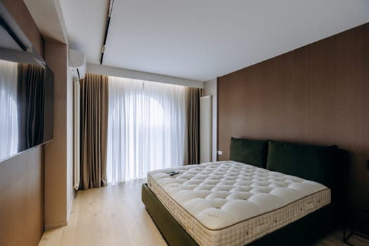 The bedroom features a comfortable mattress placed on a bed and a flatscreen television mounted on the wall for entertainment purposes