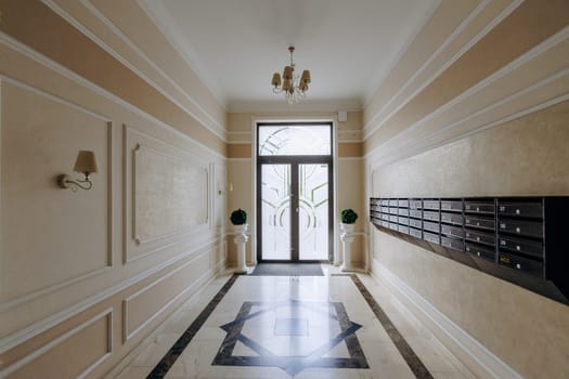 A long and spacious hallway inside a building featuring a large number of mailboxes mounted on the wall, creating a functional yet efficient area