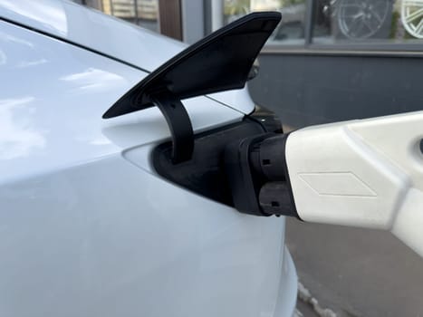 Electric vehicle charging with modern connector, symbolizing transition to clean energy and sustainable transport powered by green electricity and eco-friendly solutions
