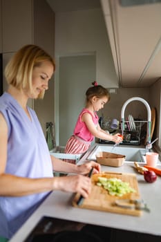 Parents and kids joyfully prepare fresh ingredients together.